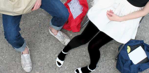 Kahden nuoren jalat ostoskassien ympäröimänä