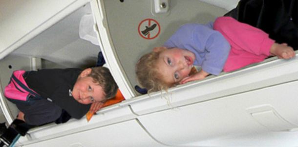 Lapset lentokoneen matkatavarahyllyllä