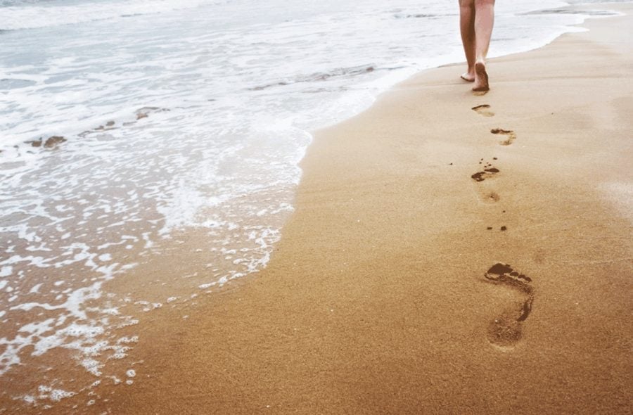 Nainen kävelee rannalla
