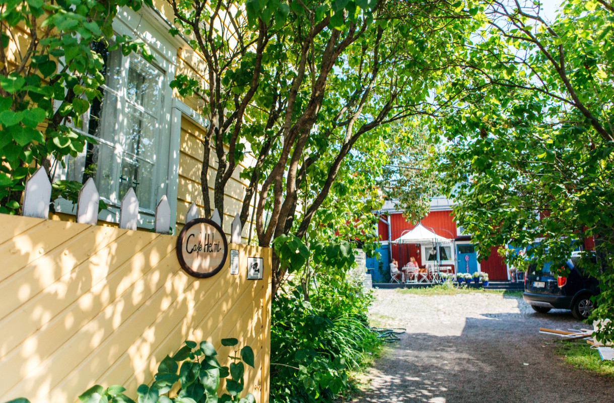 Kurkistus vehreälle sisäpihalle, edustalla puun lehdet