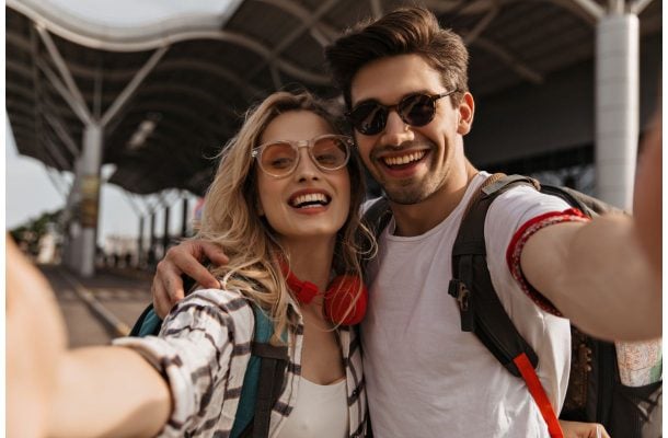 Nainen ja mies ottamassa selfietä lentoasemalla.
