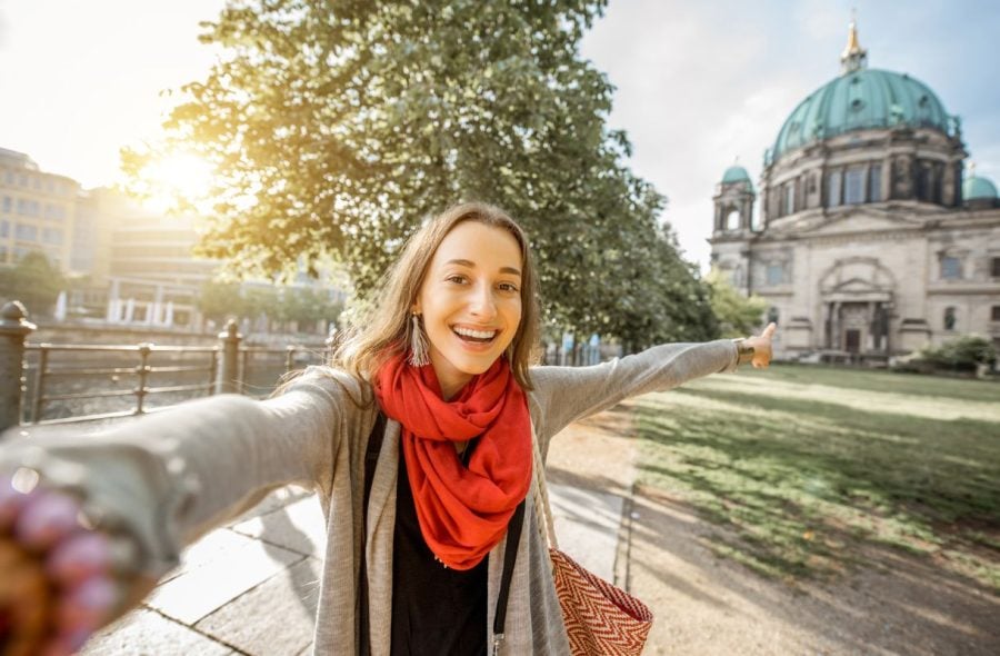 Nainen ottamassa selfietä vanhan museorakennuksen edessä Berliinissä.