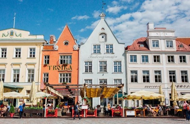 Tallinnan vanhankaupungin historialliset värikkäät rakennukset vierekkäin, edustalla patio.